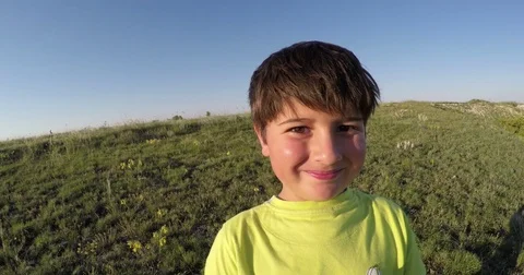 Dark-haired boy smiling against the blue sky Stock-Footage 76471671