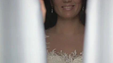 Dark-haired bride near the window in hotel room opening the curtain Video stock 94211248