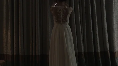 Dark-haired bride near the window in hotel room opening the curtain 動画素材 94211329