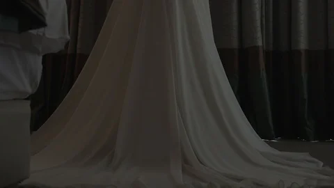Dark-haired bride near the window in hotel room opening the curtain Stock Footage 94212234