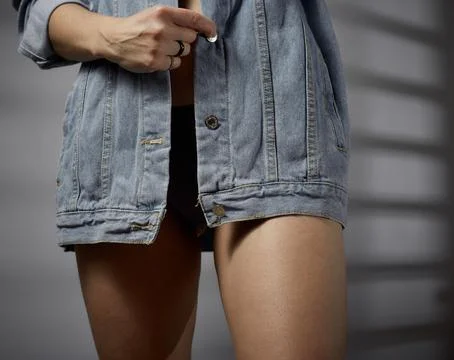 Dark-haired girl posing in the studio in a denim shirt Stock Photos