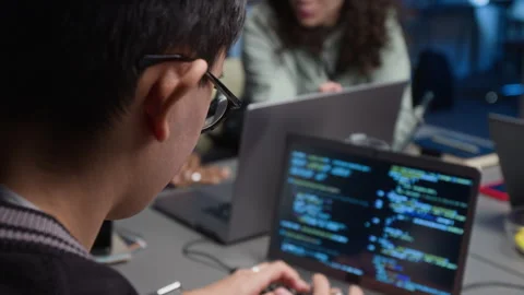 Dark-Haired IT Specialist Writing Code on Laptop Working in Office at Night Stock Footage 329615332
