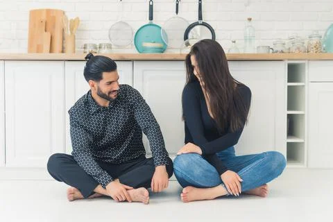 Dark-haired man with beard looking at his girlfiend with dark long hair smiling Stock Photos