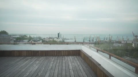 Dark haired man in casual clothes with journal in hand walking on wood rooftop l Stockbeeldmateriaal 132675463