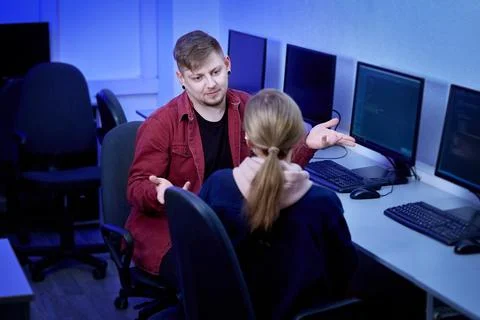 A dark-haired man communicates with a young woman and discusses work. Foto stock