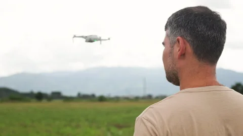 Dark haired man enthusiastically pilots drone. Outdoor recreation combined with Video stock 322565510