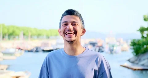 A dark-haired man making childish and funny faces at the camera by a beach Vídeo Stock 305878186