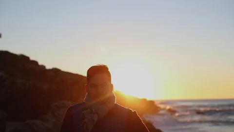 Dark-haired man runs across the ocean at sunrise Stock Footage 130001472