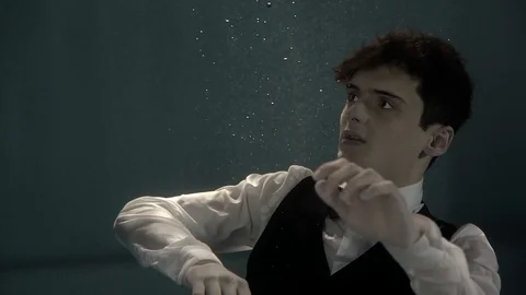 Dark haired man is sinking underwater and floating to surface Video stock 88888942