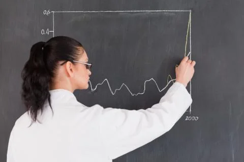 Dark-haired scientist drawing a graph on the blackboard Stock Photos