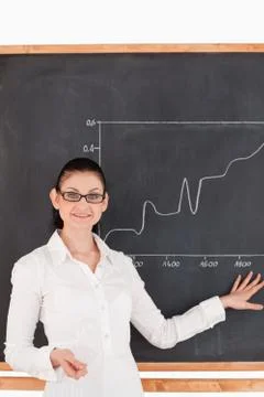 Dark-haired teacher explaining a graph to students Stock Photos