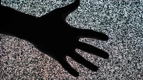 Dark Hand Silhouette Across Static Television Screen Stock Footage 310606650