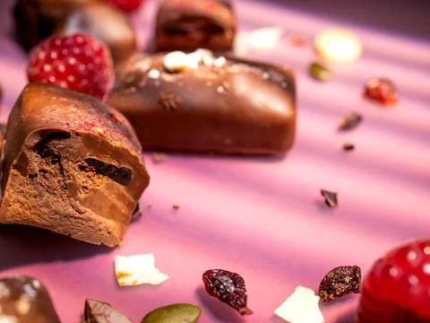 Dark handmade chocolate stack, coconut chips, raspberries and nuts Stock Photos
