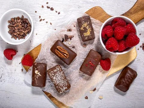 Dark handmade chocolate stack, coconut chips, rasberries and nuts Stock Photos