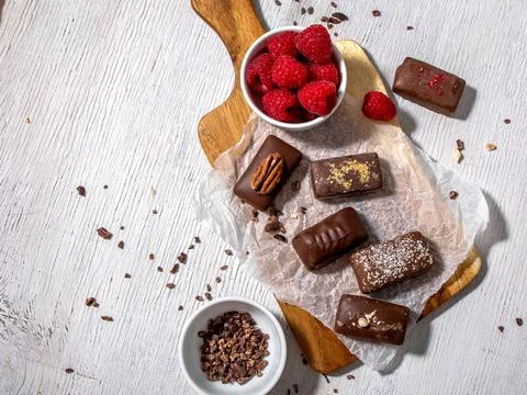 Dark handmade chocolate stack, coconut chips, rasberries and nuts Stock Photos