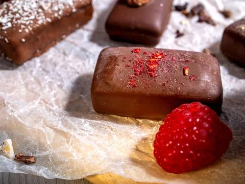 Dark handmade chocolate stack, coconut chips, rasberries and nuts Stock Photos