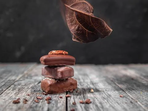 Dark handmade chocolate stack with dry leaf and cacao chips Stock Photos
