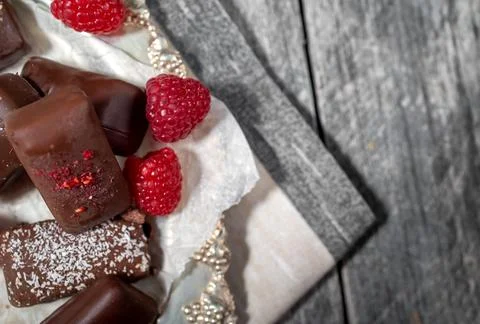 Dark handmade chocolate stack with raspberries and nuts Stock Photos