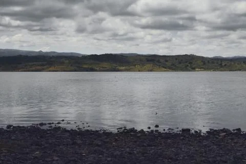 Dark, heavy rain clouds over the rocky shores of lake La Florida, in San Luis Stock Photos