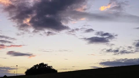 Dark Hillside Silhouette Beneath Fading Sunset Clouds Stock Footage 345654552