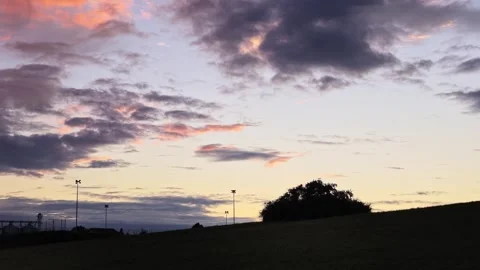 Dark Hillside Silhouette Beneath Fading Sunset Clouds Stock Footage 346039128