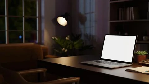 Dark home office with white screen laptop on wooden table beside bookshelf .. 스톡 일러스트