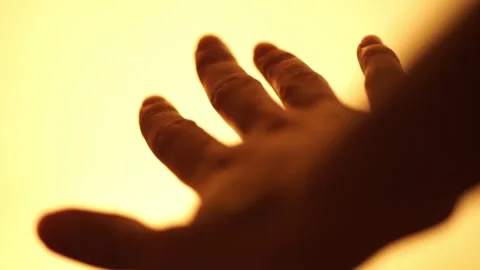 Dark human hand is flying in a warm yellow space Stock Footage 133651372