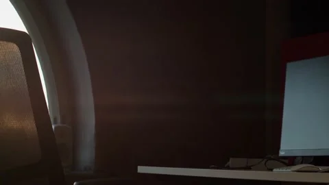 Dark interior office pan from large window arch to computer on desk Stock Footage 198888056