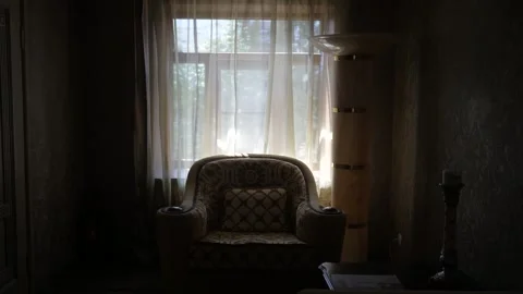 Dark interior with vintage armchair on the background of a window with curtains Stock Footage 144673166