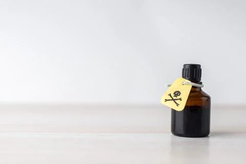Dark jar with poisonous solution, etiquette with a warning sign about the con Stock Photos