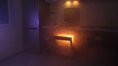 Dark kitchen filled with thick smoke and glowing orange light from an open oven Stock Footage 305245733
