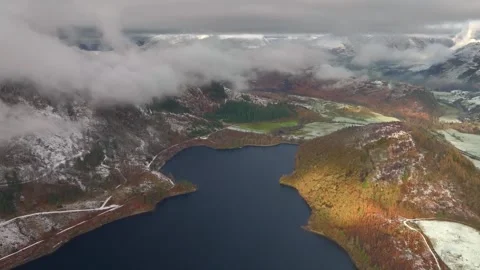 Dark lake and mountains with light snow and patch of early morning Stock Footage 258440091
