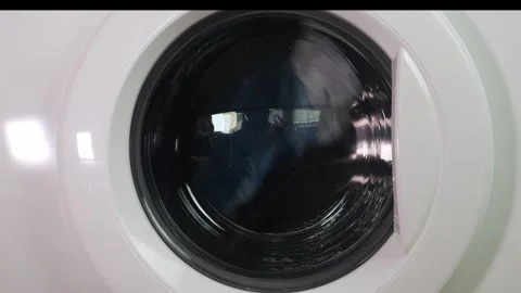 Dark laundry is being washed in a washing machine, the drum with water and .. 库存影片 315065593