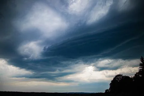 Dark Layered Storm Clouds Rolling Over Forest Horizon Stock Photos