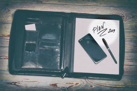 Dark leather bag for documents. in it the inscription of the word plan. There Stock Photos