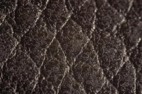 Dark leather surface with raised diamond stitching pattern Stock Photos