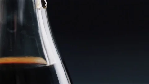 Dark liquid drop slowly running down the glass bottle Stock Footage 104720051