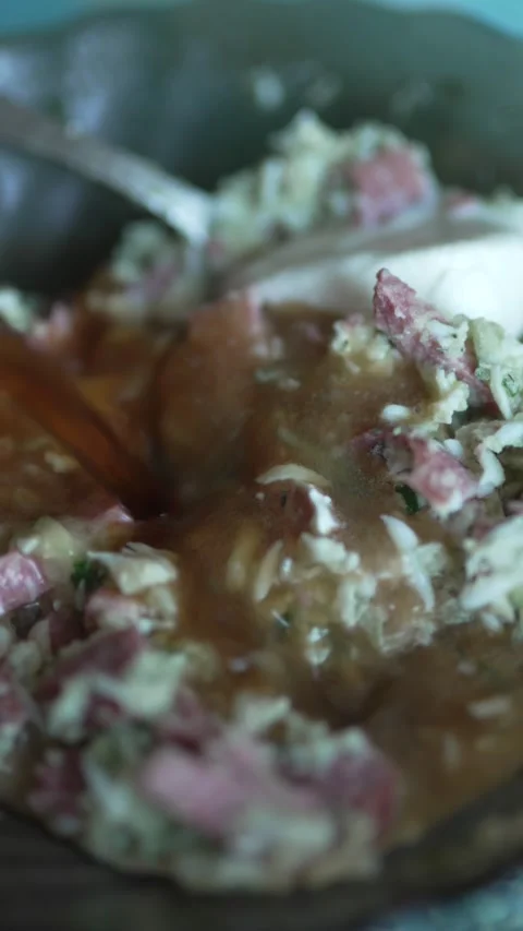Dark liquid pours over chopped salad with sausage and cream Stock Footage 333634212