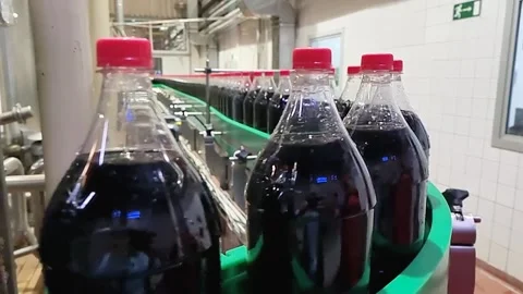 Dark liquid sweet soft drink moving at conveyor footage Stock Footage 153818826