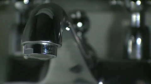 Dark lite faucet with slow drip. (v.1) Stock Footage 1094449