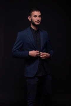 Dark, low light model buttoning jacket suit Stock Photos
