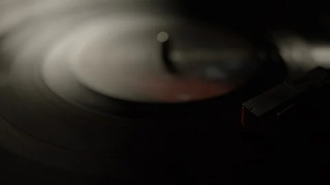 Dark macro of stylus needle on spinning vinyl record Stock Footage 129574493