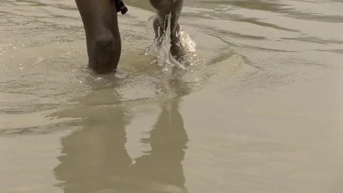 Dark man walking in the shallow water in slow motion Stock Footage 81310859