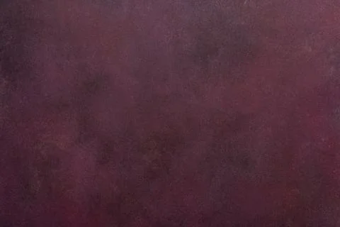 A dark maroon surface exhibits a subtle texture. Light and dark variations .. Foto stock