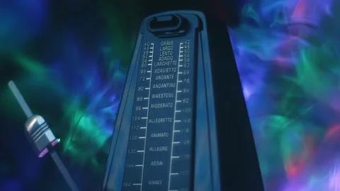 In the dark a modern metronome, with a swinging pendulum, in smoke Stock Footage 313145345