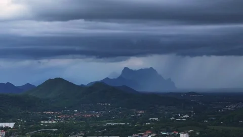 Dark monsoon clouds unleash rain over tropical mountain valley in dramatic Stock Footage 314762228