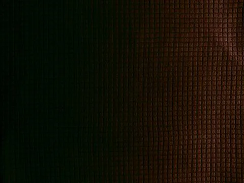 Dark moody abstract grid texture fading into shadowy abyss with subtle warm h Stock Photos