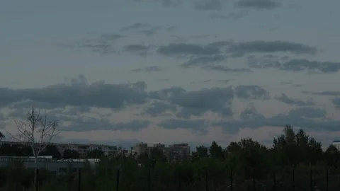 Dark moody clouds floating over a quiet city at dusk Stock Footage 334627760
