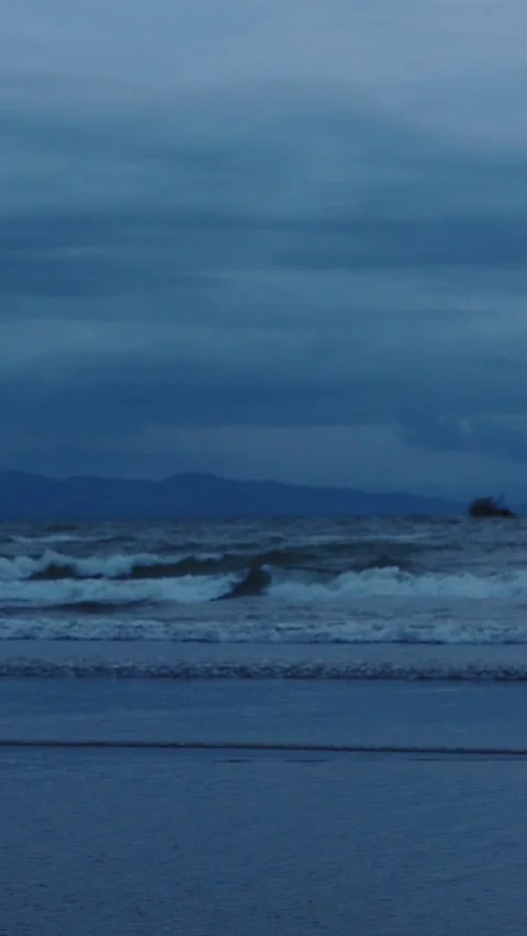 Dark moody dusk scene of the beach aftermath of a tropical storm Stock Footage 280493060