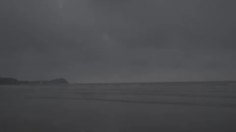 Dark moody sea under heavy overcast sky with distant shoreline.beach, waves Stock Footage 336796680